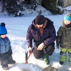 Éliott et Olivier observent la ligne à pêche tendue par Jean-Sébastien Hardy-Painchaud, instigateur du festival Les Hivernades en Haute-Côte-Nord.
